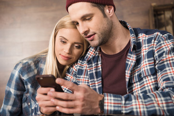 Attractive casual young couple using smartphone together