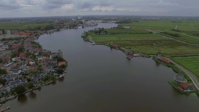 Aerial flight above the Koog Zaandijk, Netherlands. View of town on the one side of river and agricultural fields on the other side