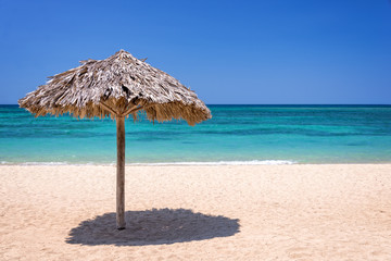Straw umbrella on a beautiful tropical beach