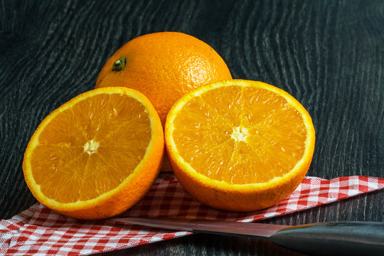 Oranges sur fond noir avec couteau et serviette