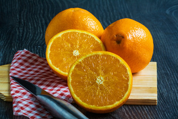 Oranges sur fond noir avec couteau et serviette