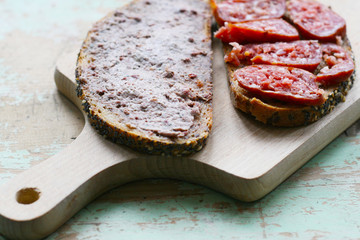 Brotzeit - dunkles Brot mit Wurst, Leberwurst und Bratwurst, herzhaftes Essen, Wurstwaren