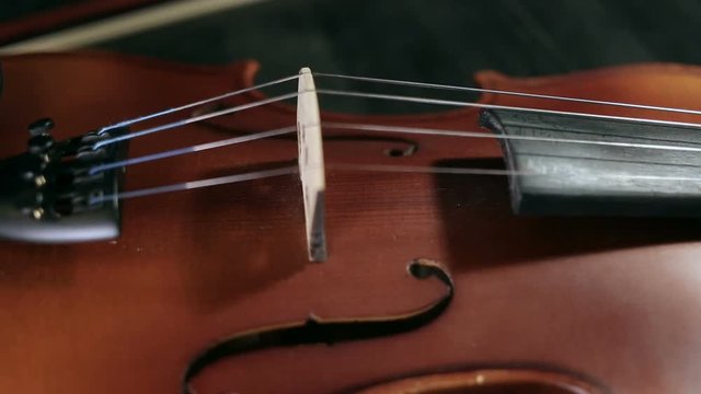 close up rotation shot of part of aged violin on black background