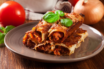 Naklejka premium Baked cannelloni with minced meat and bechamel sauce on a plate
