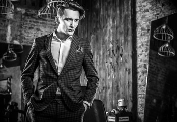 Naklejka premium Elegant young man in barbershop. Black-white photo.