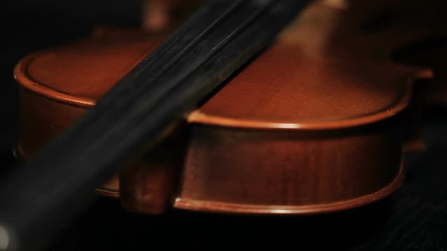 extreme close up panoramic shot of part of aged violin on black background