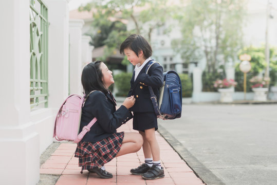 Asian Schoolgirl helps to dress her brother's uniform