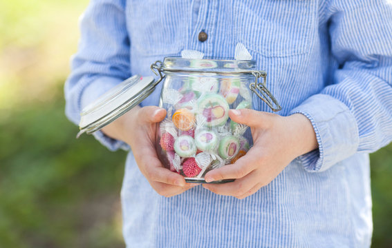 child holding a jar full of sweets