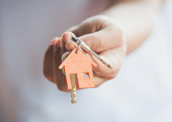 Female hand holding house key,real estate agent.