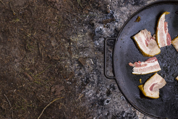 Fat fried bacon on the big black pan - perfect forester's dinner