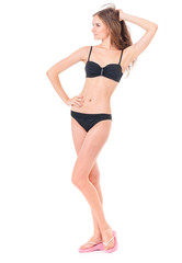 Obraz premium Sexy młoda kobieta stwarzających w czarnym bikini, na białym tle