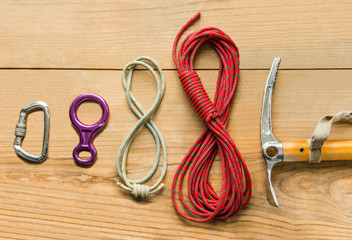 climbing equipment: rope, ice tools, ice ax, eight, carbine on wooden background, top view