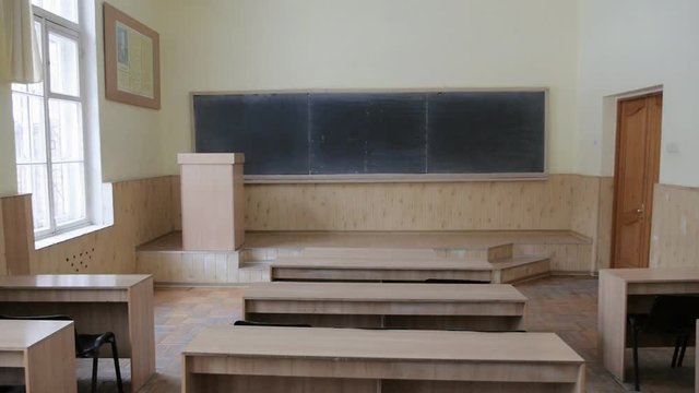 A panoramic view of the auditorium, a lecture hall with a podium and a blackboard
