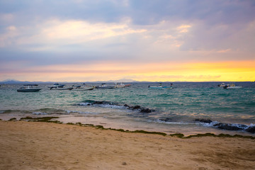 Fototapeta na wymiar Sunset over Madagascar Nosy be beach with boat silhouettes