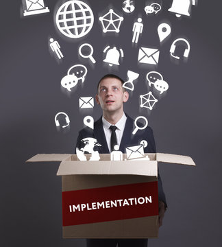 Business, Technology, Internet and network concept. Young businessman shows the word: Implementation