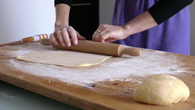 Italian woman rolling pin on fresh pasta
