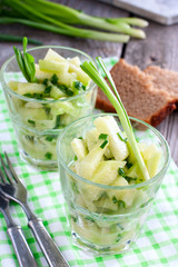 Vegetarian salad with fresh radish and green onions in glass jars, selective focus