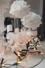 Holiday table decoration with white candles and bulb garland