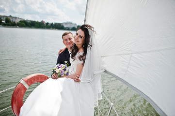Wedding couple in love at small sailboat yacht on lake.