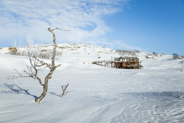 An old, abandoned copper mine building in the snowy Norway landscape