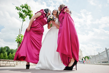 Fototapeta premium Bride walking and having fun with charming bridesmaids on rose dresses.
