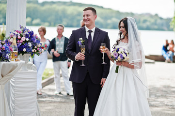 Wedding couple with glasses of champagne at wedding ceremony.