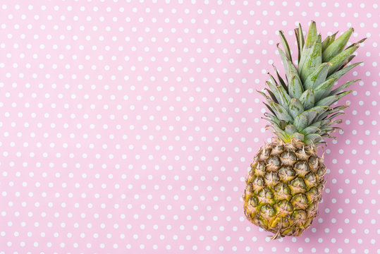 Fresh pineapple on pink dotted background