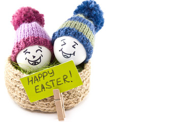 Easter eggs in a basket. Emoticons in knitted hats with pom-poms. Knitted basket of jute, sisal green. Handmade.