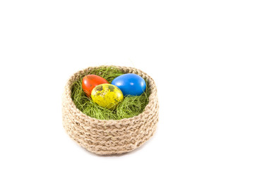 Easter eggs in a basket.Painted Quail eggs. Knitted basket of jute, sisal green.