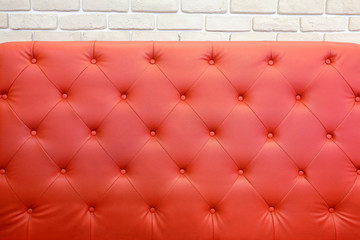 Red sofa against white brick wall background