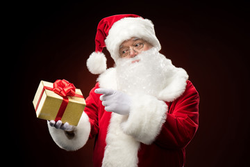 Santa Claus pointing on gift box