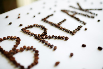 Creative coffee break concept: Word Break laid out on white table with rich roasted coffee beans in large letters