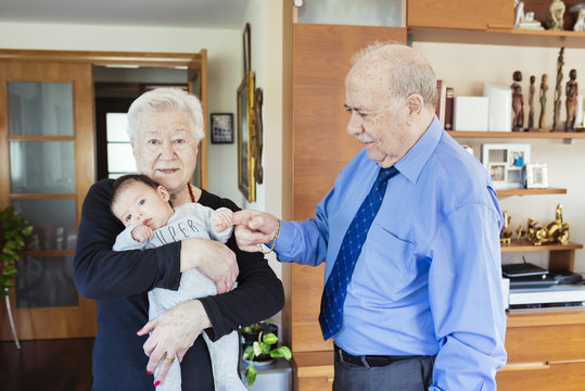 Great-grandparents with baby at home