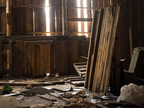 Rubbish, garbage in an old wooden barn. Rays of light