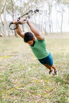 Man doing suspension training outdoors