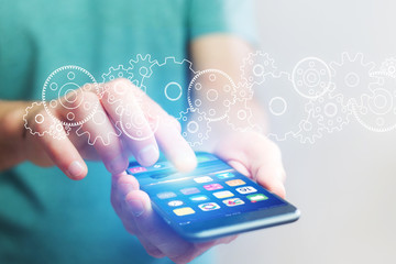 Concept of cogwheel setting going out of a smartphone