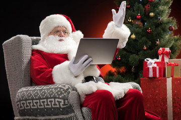 Santa Claus using laptop and gesturing