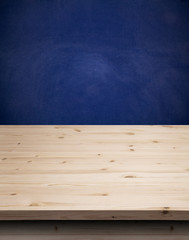 Empty wooden table for product display over grunge blue wall