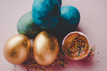 Fototapeta na wymiar colorful blue and golden easter eggs with confectionery sprinkling