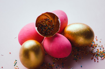 colorful pink and golden easter eggs with confectionery sprinkling