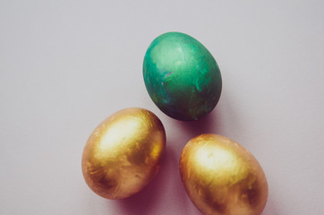Fototapeta na wymiar colorful green and golden easter eggs with confectionery sprinkling