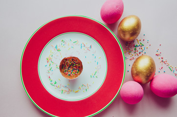 colorful pink and golden easter eggs with confectionery sprinkling on plate