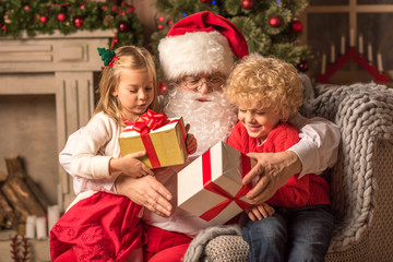 Fototapeta na wymiar Santa Claus with children holding gift boxes