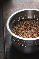 Buckwheat in the metal  colander vertical