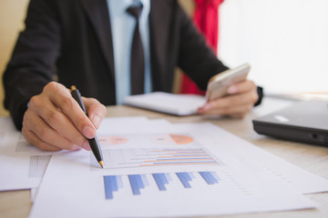 Businessman check business profits with on project at office desk in office. Concept investor and finance morning light. Concept business and financial