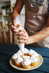 Closeup of unrecognizable man working in rustic kitchen, putting finishing touches on  freshly...