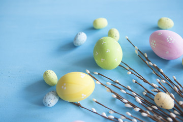 Easter eggs painted in different colors near willow twigs