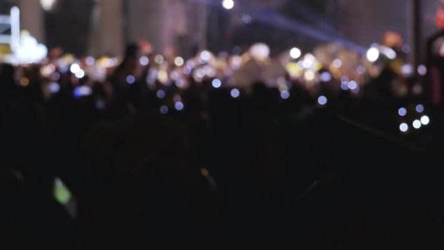 New Year's concert, people dancing in the square with balloons and sequined hats