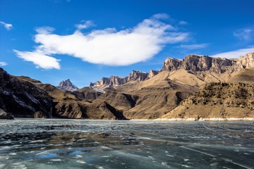 Fototapeta na wymiar замерзшее озеро в горном ущелье, весна, горные склоны, природа Северного Кавказа, красивый пейзаж
