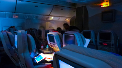 dim lights in the cabin of passenger aircraft during long-distance flights, passengers are rest © ppicasso